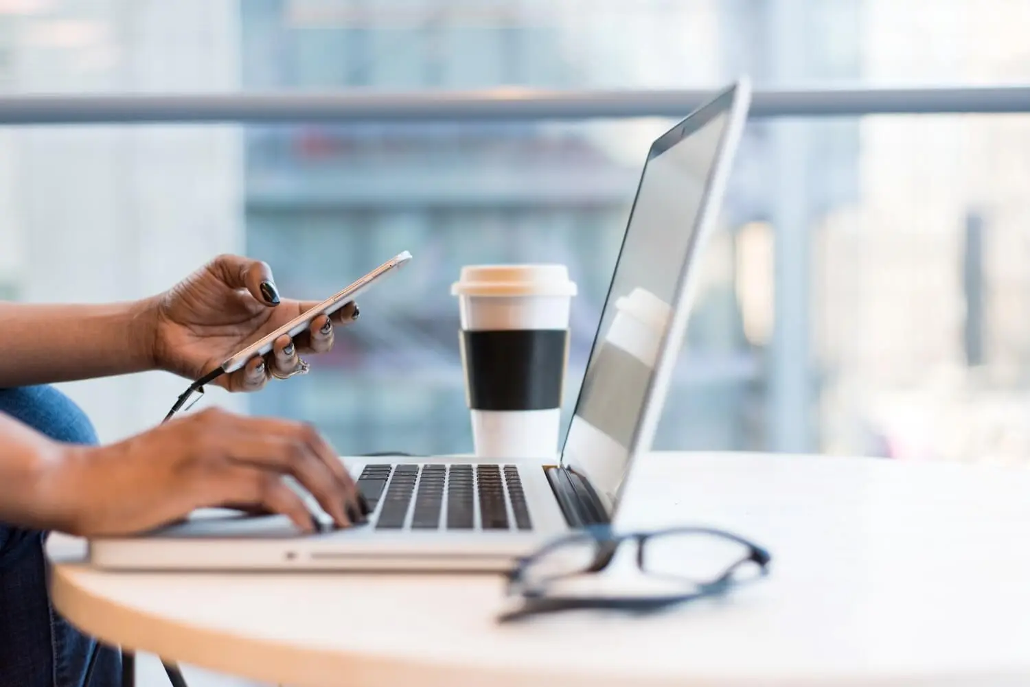 person-using-a-laptop-and-a-phone-at-work