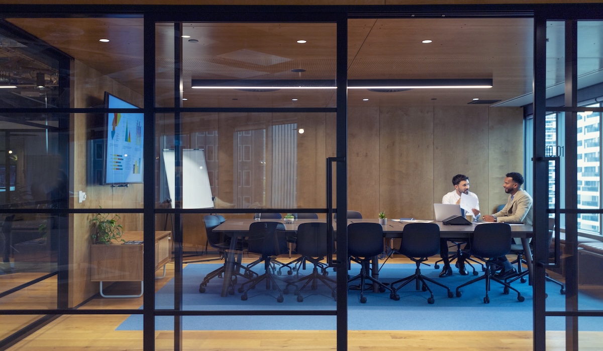 Business people working in a board room with a laptop and digital tablet